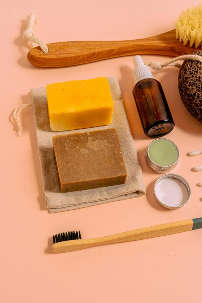 Aesthetic display of natural soaps and toiletries on a pink surface, promoting sustainable lifestyle.